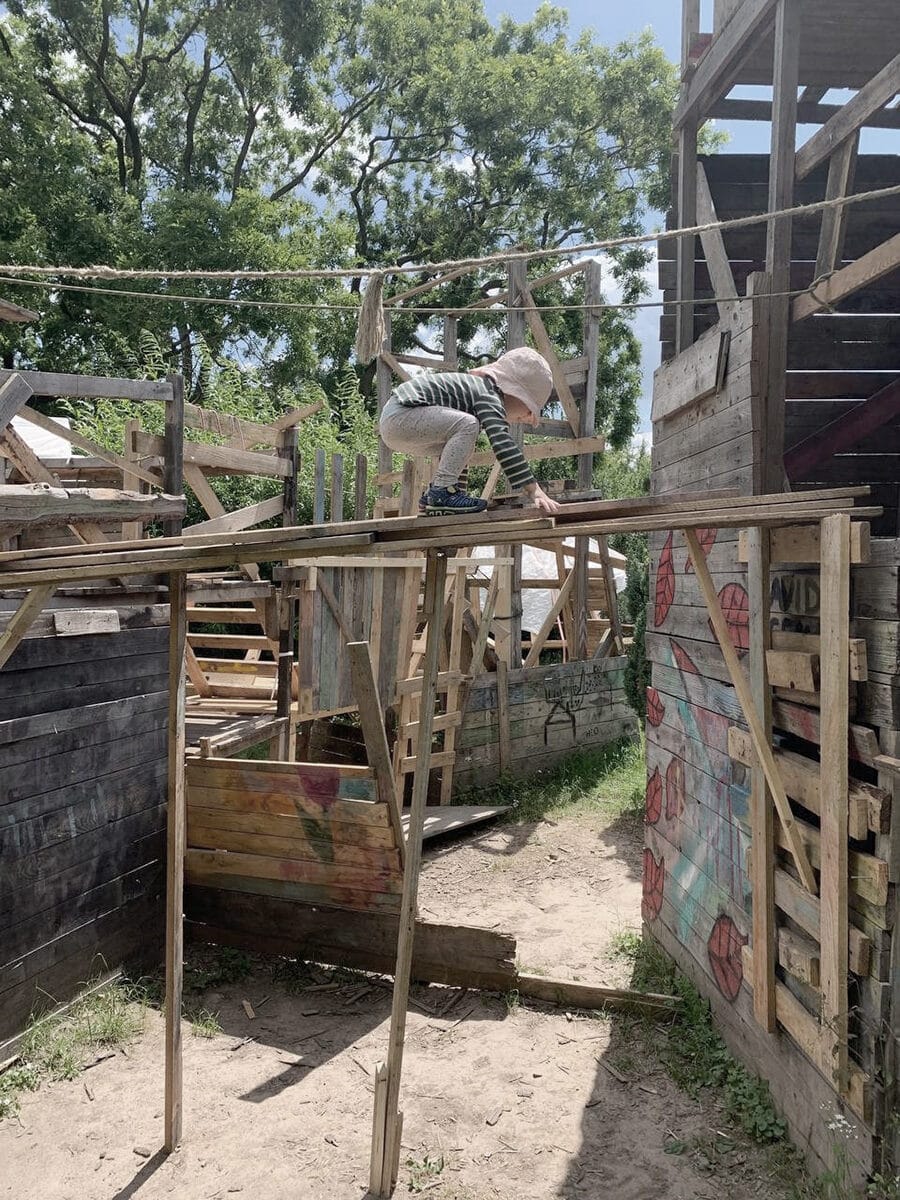 Kind begeht Brücke auf einem Abenteuerspielplatz
